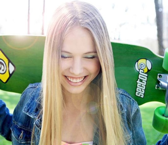 Smiling girl with skateboard