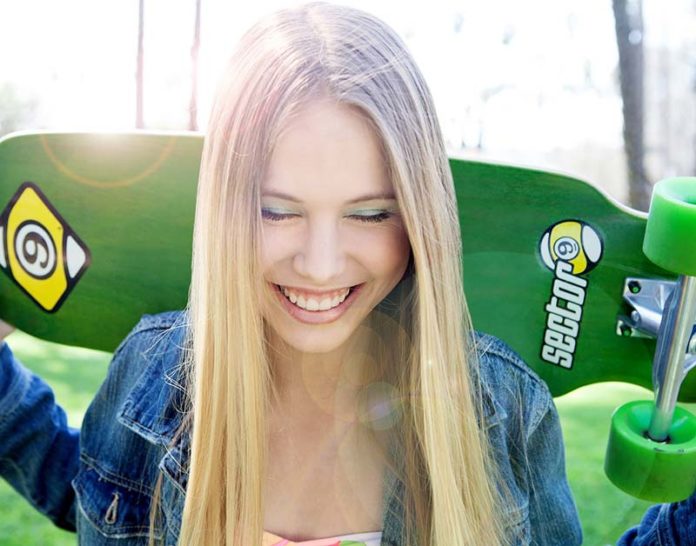 Smiling girl with skateboard